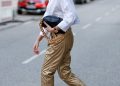 HAMBURG, GERMANY - FEBRUARY 23: Best Ager Model and Influencer Petra van Bremen wearing sunglasses by Saint Laurent, a white blouse by Zara, gold metallic pants by Summum Woman, a black bag with a chunky gold chain by Bottega Veneta and white boots by Zara during a street style shooting on February 23, 2021 in Hamburg, Germany. (Photo by Streetstyleshooters/Getty Images)